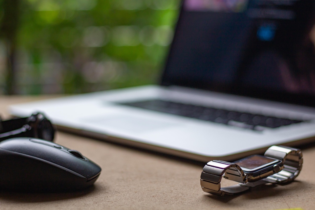 Laptop, mouse, and watch on a desk for a small-business website conversation