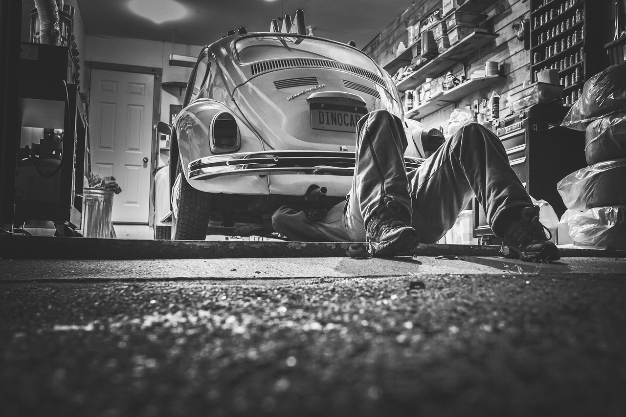 Mechanic working under a car, a reminder that maintenance keeps things running