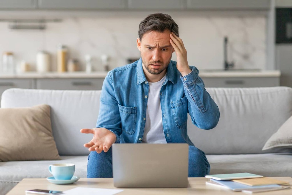 Business owner frustrated with a confusing website on a laptop